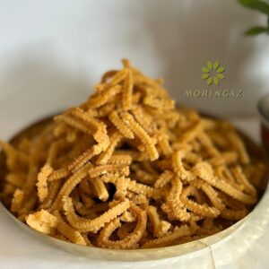 Golden, crispy Rice Murukku in a bowl with tea and sesame seeds—handmade South Indian snack, fresh and preservative-free.