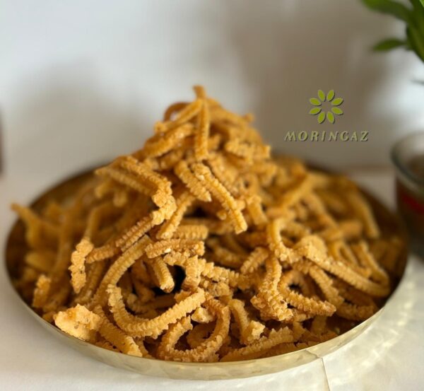 Golden, crispy Rice Murukku in a bowl with tea and sesame seeds—handmade South Indian snack, fresh and preservative-free.
